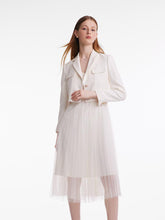 A lady wears a white dress suit.